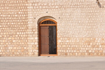 Fototapeta na wymiar Wooden door and Coral wall of arab architecture ,sharjah Uae .