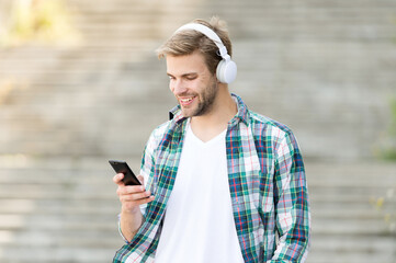 Disconnect from the outer world. Happy guy make video call using mobile phone. Handsome man listen...