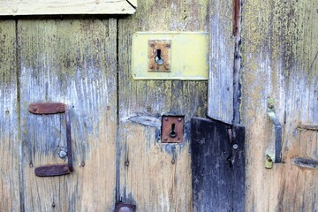 old wooden door with several keyholes