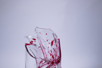 drops of red liquid - blood - on the fragments of a broken glass in a broken glass on a white background. Isolated. Copy space. pain concept. High quality photo