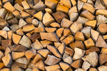 Stack (woodpile) of firewood for rural energy resources. Dry chopped wood logs in a pile close up