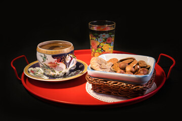 Alongside Turkish coffee presentation, various dried nuts. On black background