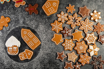 Various christmas gingerbread cookies on dark table with flour