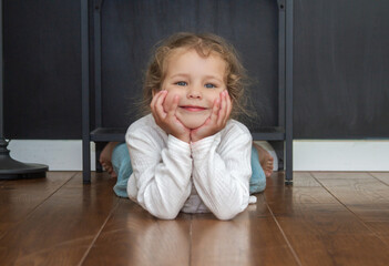 Little cute girl in a bright room, a minimum of objects in the room, the child rejoices, baby...