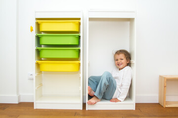 Little cute girl in a bright room, a minimum of objects in the room, the child rejoices, the child...
