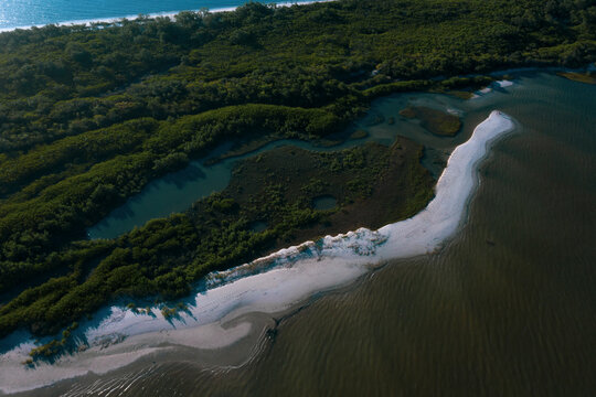 Brazil, Florianopolis. Panoramic aerial view of Daniela beach pontal peninsula and river showing sea, sand, trees and an small internal lake.