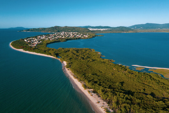 Brazil, Florianopolis. Panoramic aerial view of Daniela beach pontal peninsula and river showing sea, sand, trees and an the village.