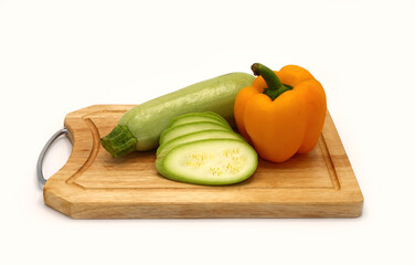 Zucchini and ripe sweet pepper of different colors on a cutting board on a light background. Natural product. Natural color. Close-up.