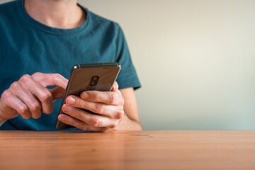 young man using his smartphone and texting inside his house