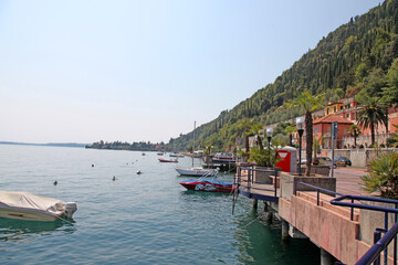 Fototapeta na wymiar Lake Garda, in northern Italy surrounded by hills and villages with boats in the water
