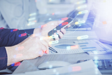 Double exposure of man's hand holding and using a digital device and data theme hologram drawing. Technology concept.