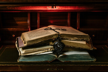 old books stacked with a pocket watch