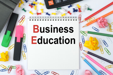 On the table is a calculator, diary, markers, pencils and a notebook with the inscription - Business Education