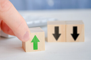 The concept of development and success in business. Wooden cubes with an arrow on a yellow background.