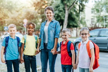Happy children enjoying outdoors with their teacher.
