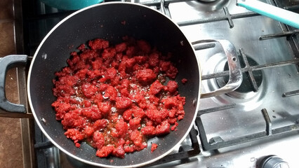 fried red chorizo ​​cut into small pieces in a pan sewn on a stove