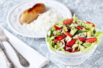 summer salad with strawberries, avocado, lettuce, onion,cucumber , green peas. dressed with balsamic sauce. copy space
