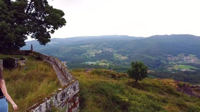 Young woman walking on the top of a mountain in Galicia