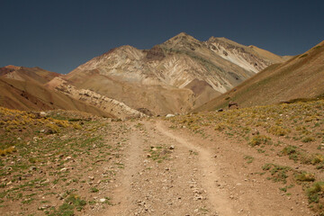Outdoors activity. Hiking. Dirt path across the arid mountains and desert.