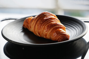 Croissant on a black ceramic plate