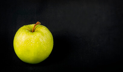 Ripe green apple on a black background