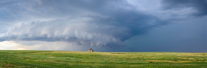 Fototapeta na wymiar Abandoned farmstead structures on the Great Plains with Dramatic Skies Overhead