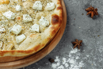 four cheese pizza, italian pizza. pizza stuffed with four varieties of cheese on a gray background.