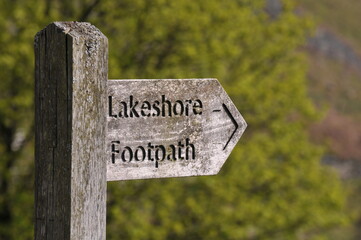 wooden lakeshore footpath sign in the countryside