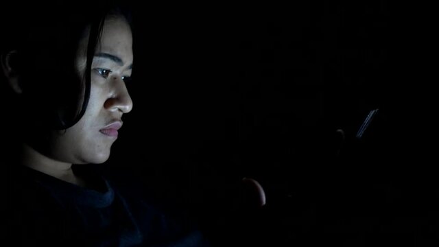 asian woman touching on tablet screen at night. 