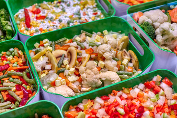 A variety of frozen foods lie in white cups.