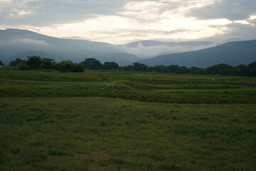 朝日の見える丘　草原　風景　山々　早朝　夏休み