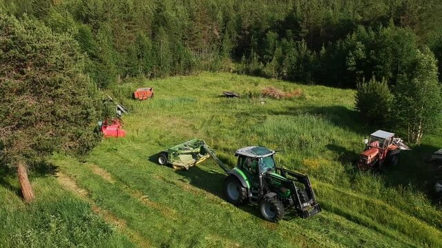 Mounted agricultural mowing machine mounted on tractor mowing down grass
