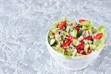 Salad with strawberries, quinoa, avocado, cucumber, lettuce, onions and green peas. vegetarian food.copy space