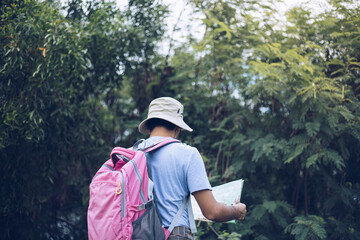 Rear View Man traveling backpacker with hat in 
forest ,Travel concept