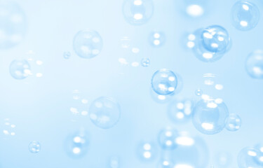 Clear blue soap bubbles float in the air. Abstract blur background.