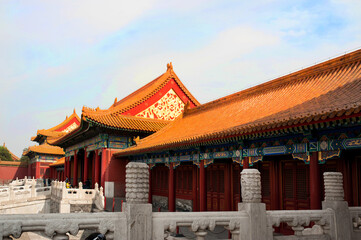 Covered courtyard in Forbidden City showing red tile roof and colorful decorated walls.