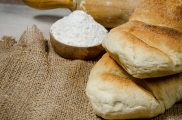 Bread prepared with a crust made in the oven with your own hands on a wooden table. flour and bakery artifacts