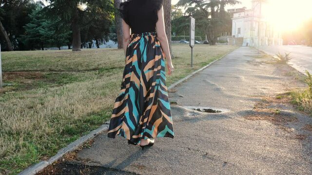 back view of elegant woman walking to the janiculum fountain on the sidewalk