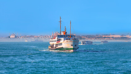 Obraz premium Famous historical peninsula of Istanbul - Hagia sophia, Sultanahmet Mosque, - Istanbul, Turkey - Water trail foaming behind a passenger ferry boat in Bosphorus, Istanbul, Turkey