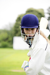 Female cricket player holding a cricket bat
