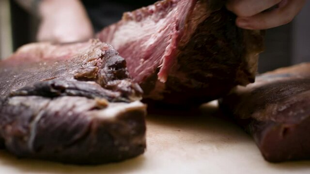 Slicing and presenting a perfect dry-aged beef brisket. Gourmet cooking and preparation. Delicious food and product shots.