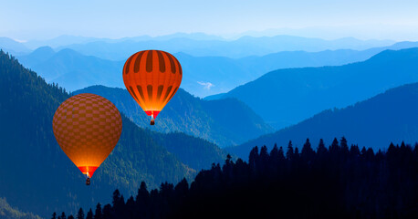 Blue mountain landscape with fog and pine forest at sunset -  Hot air balloon fly over blue mountains © muratart