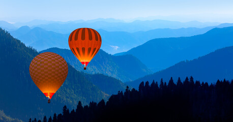 Blue mountain landscape with fog and pine forest at sunset - 
Hot air balloon fly over blue mountains