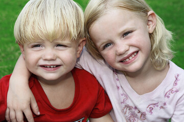 Little girl putting a hand on little boy's shoulder