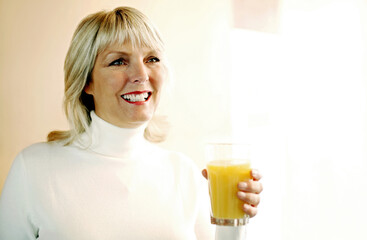 Woman holding a glass of orange juice