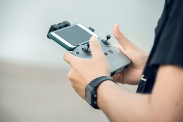 A young man with a drone flying Sunny green nature, Asian high angle photographer