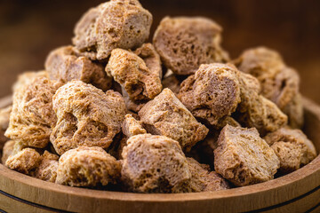 vegan food, coarse soy protein, also called soy meat, the protein textured in pieces inside a wooden bowl