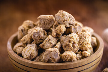 vegan food, coarse soy protein, also called soy meat, the protein textured in pieces inside a wooden bowl