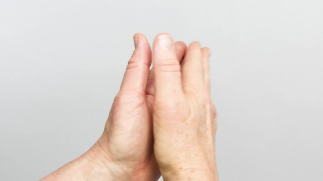 A view of hands claping from the back of the wrists is isolated on a white background.