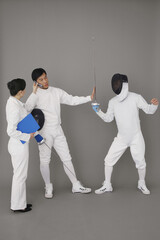 Fototapeta premium Businesswoman holding a mobile phone for a man while he stops the fencing competition